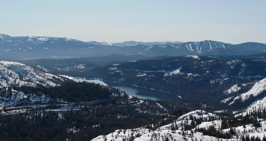 Aerial view of a river valley with snow covered hills