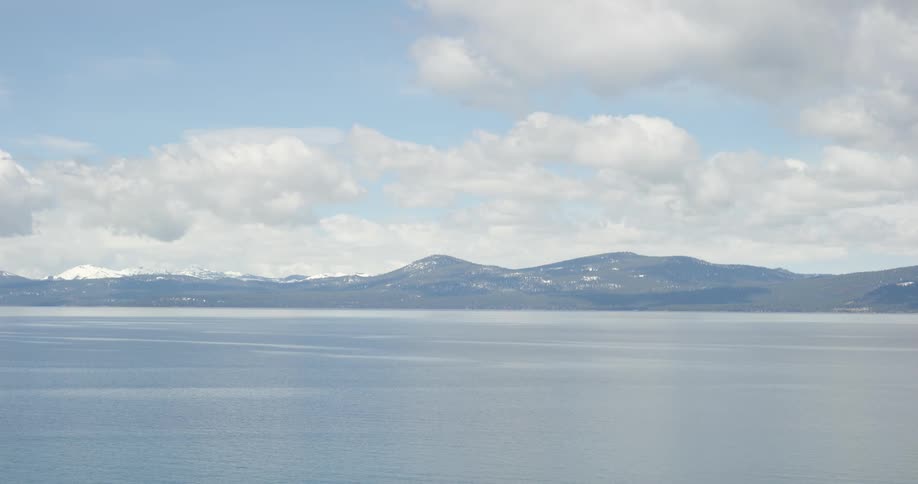 An aerial view of an ocean near the mountains is displayed