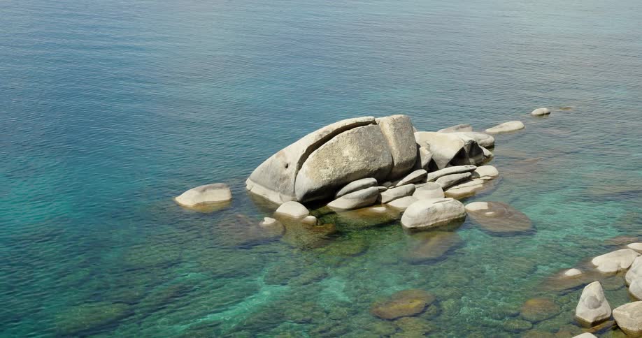 Large stones are on the shore of the beach