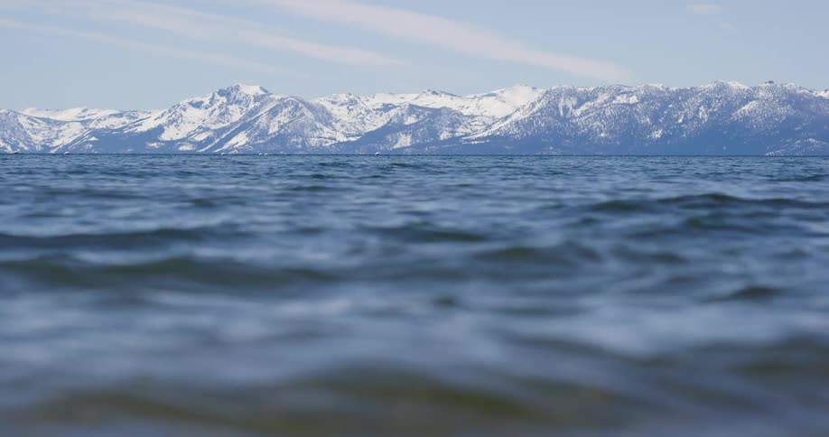 The water moves fast in the lake by the mountain