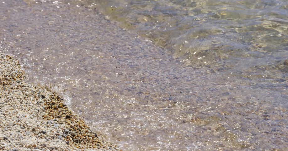 The small waves crash against the sand