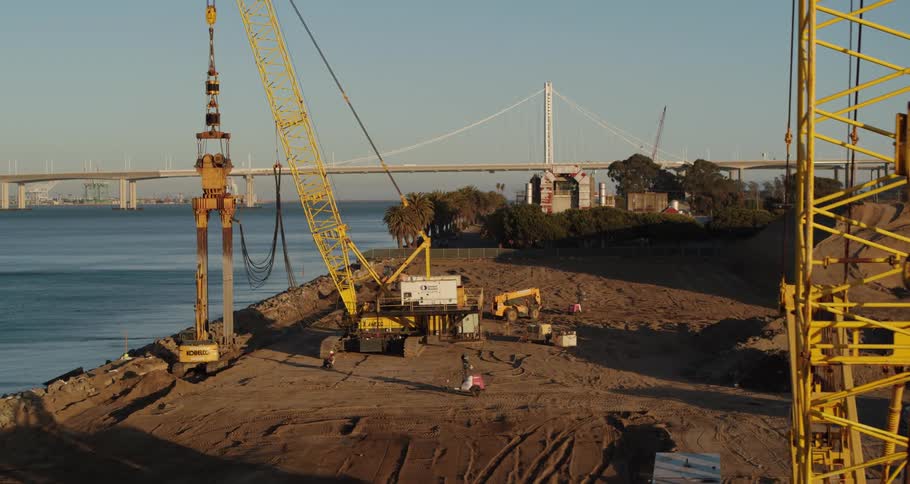 An employee drives a forklift through an oilfield next to the ocean