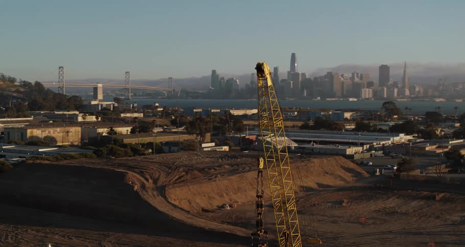 A construction crane with a city skyline behind across the water