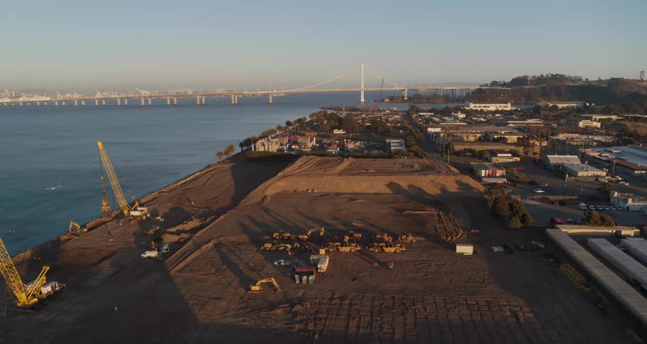 Aerial view of a construction site on the pier next to a bridge over the river