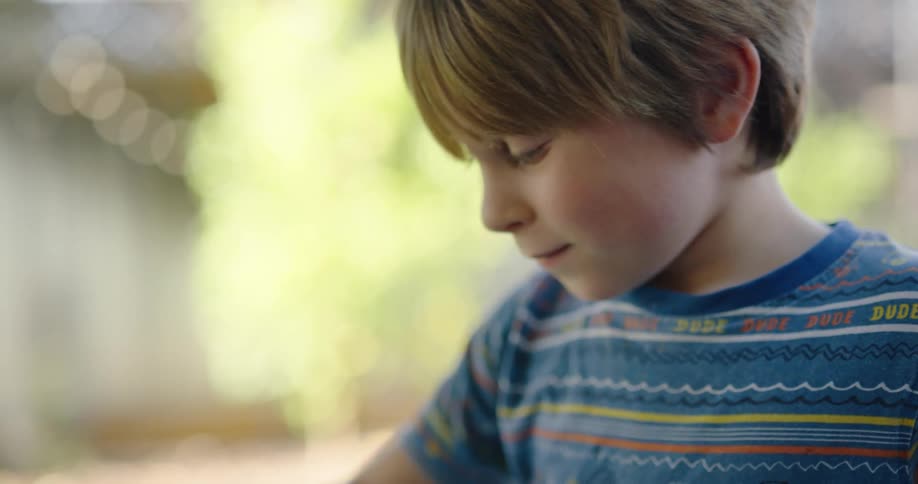 Side view of a child with a blue t shirt playing with toys