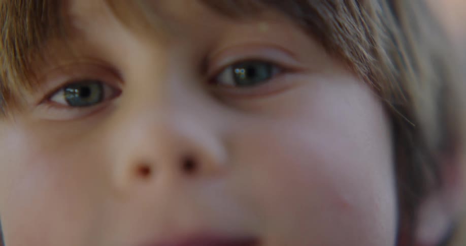 Close up of a little boy filling his cheeks up with air as he plays with a toy