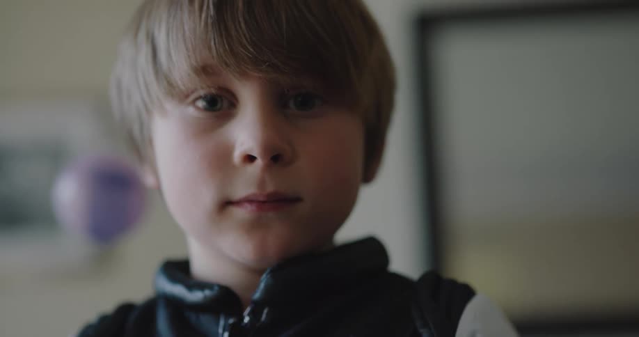 A young boy wears a jacket that is part of an astronaut costume