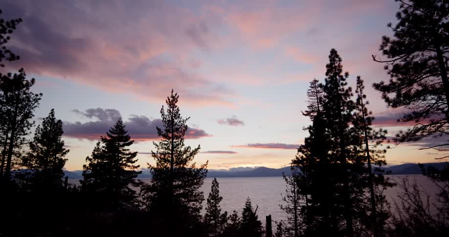 Landscape view of trees in front of a lake with hills in the distance