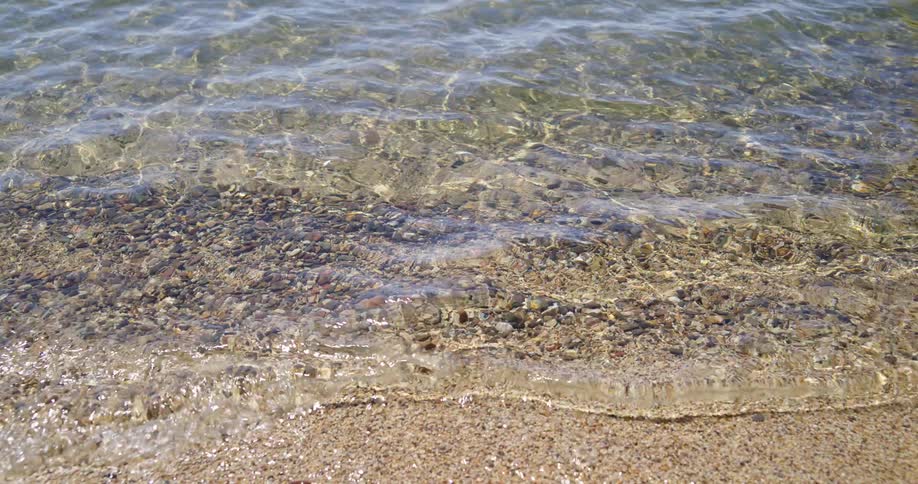 Ripples moving over rocks on the shore