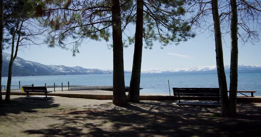 A park at the side of large bordering a snow covered mountain