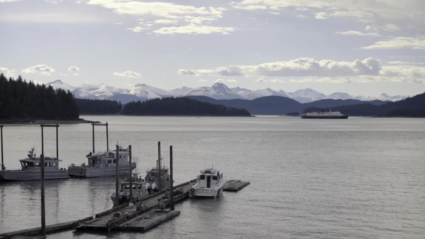 One ship remains offshore while several boats are docked