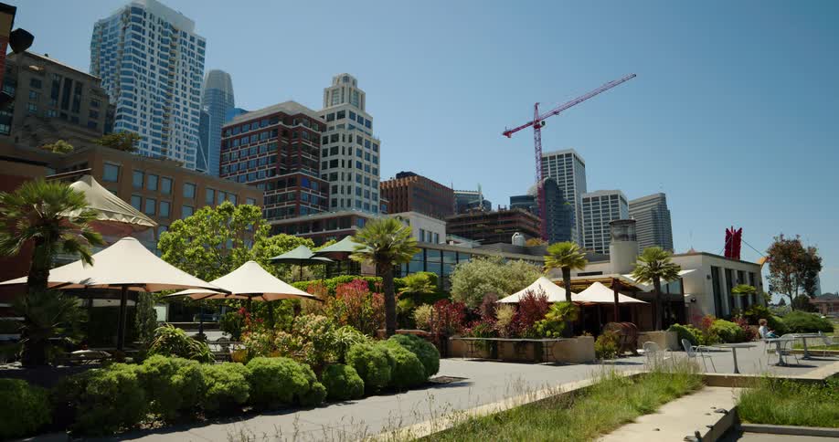 People enjoy landscaped garden near towering skyscrapers
