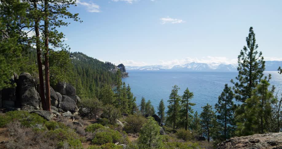 A large lake surrounded by mountains and hills covered in rock and forest