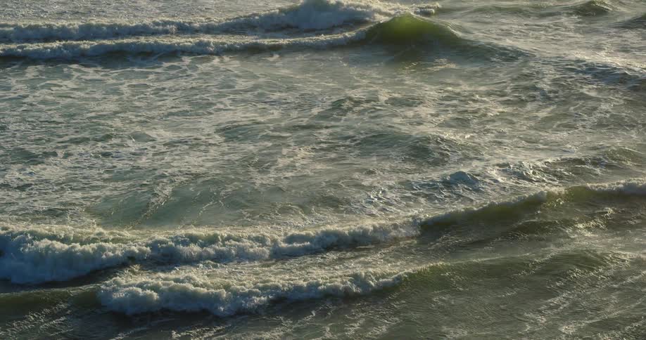 Waves rolling across the surface of the ocean during the day
