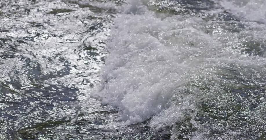 The water in a rushing river is swirling and flowing in a danger and forceful way