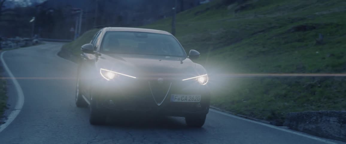 Car drives down a country road in the evening
