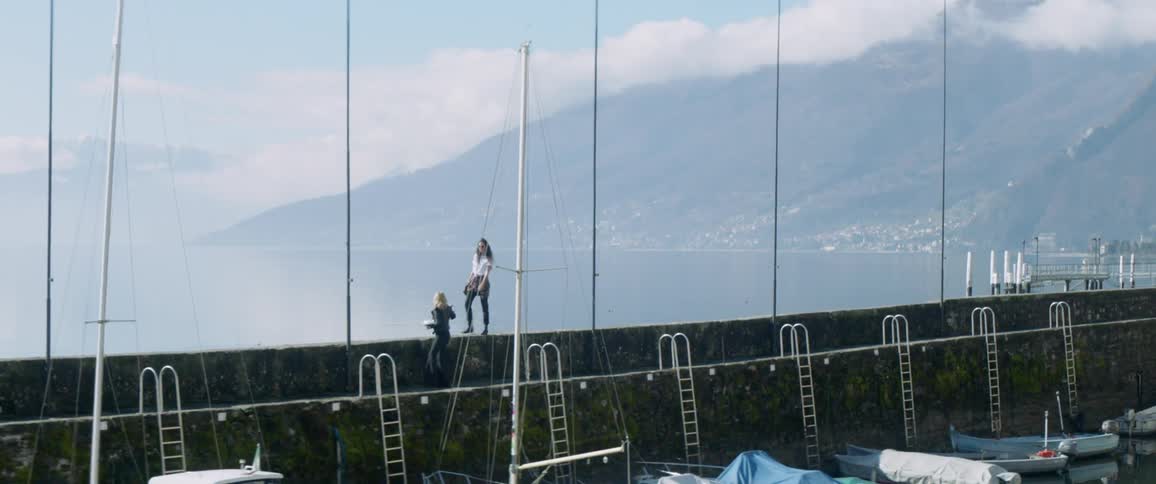 A woman walks along the bridge ledge