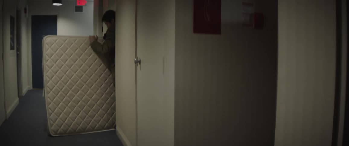 Man removing mattress from room