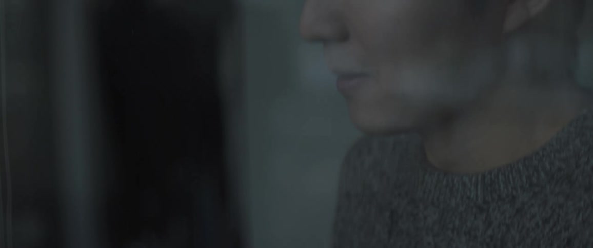 A woman is using her phone in a dark room