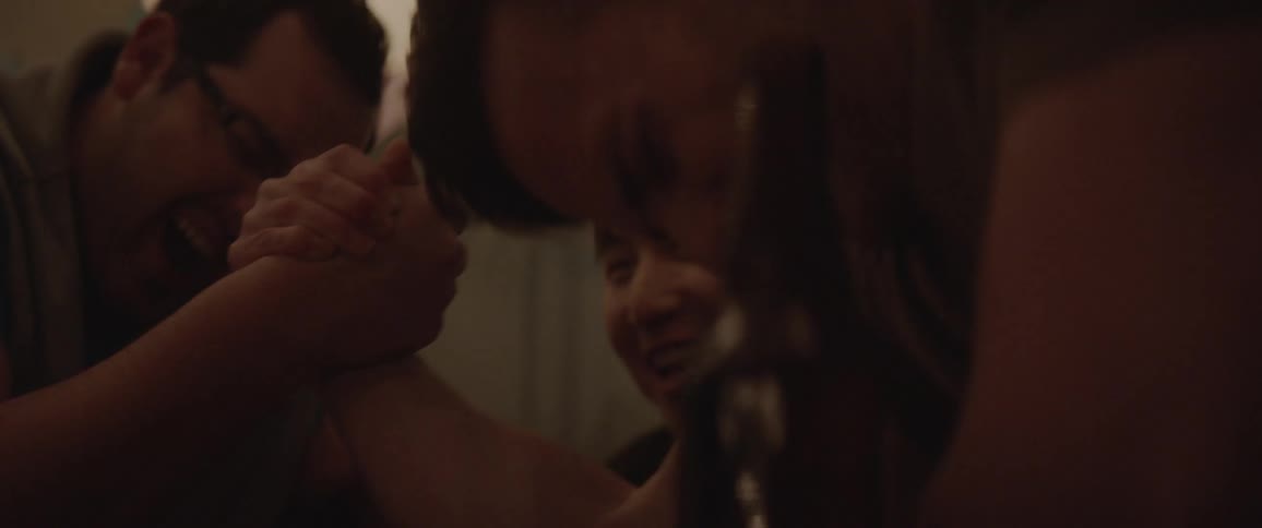 People are arm wrestling, and having fun at a party