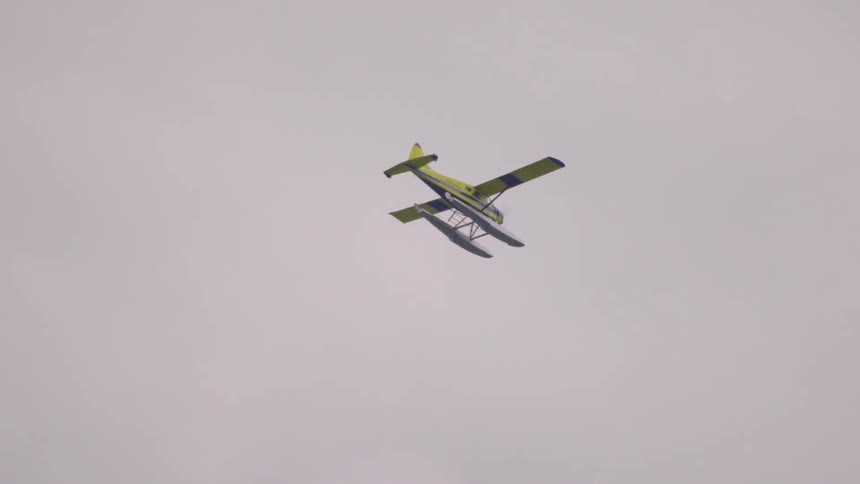 A yellow plane flies through the air