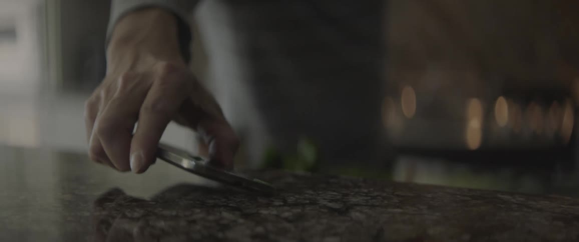 Person picks phone up off the counter and talks into it
