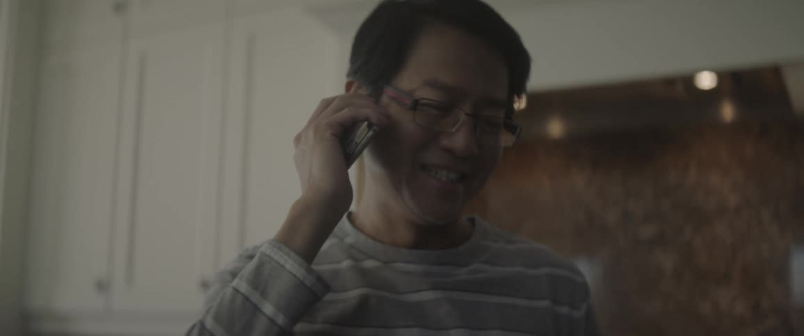 A man talks on the phone smiling