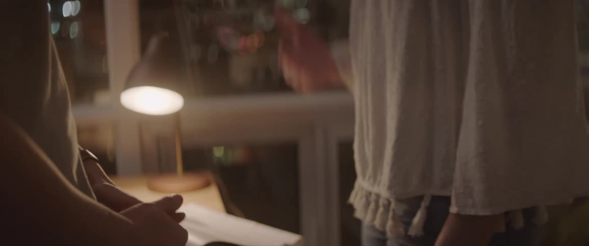 A man and woman talk in an apartment