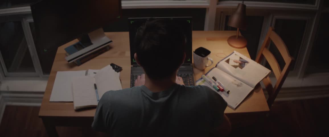 A man is sitting at a laptop working