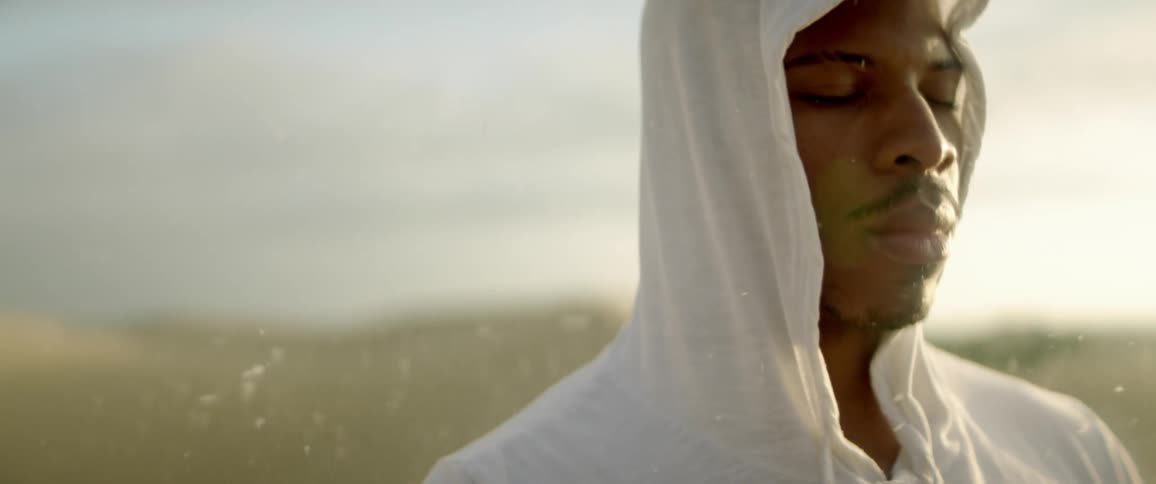 A man in a white suit is being sprayed with dust