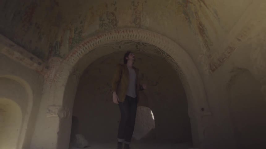 Man walking through various arches in an older building