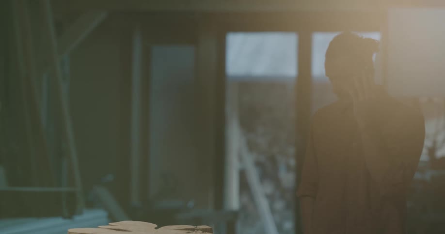 A man with a smart phone talking and walking around with a door in the background