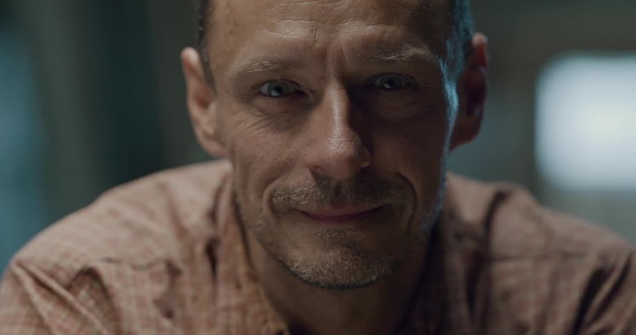 A man looks up and slowly smiles