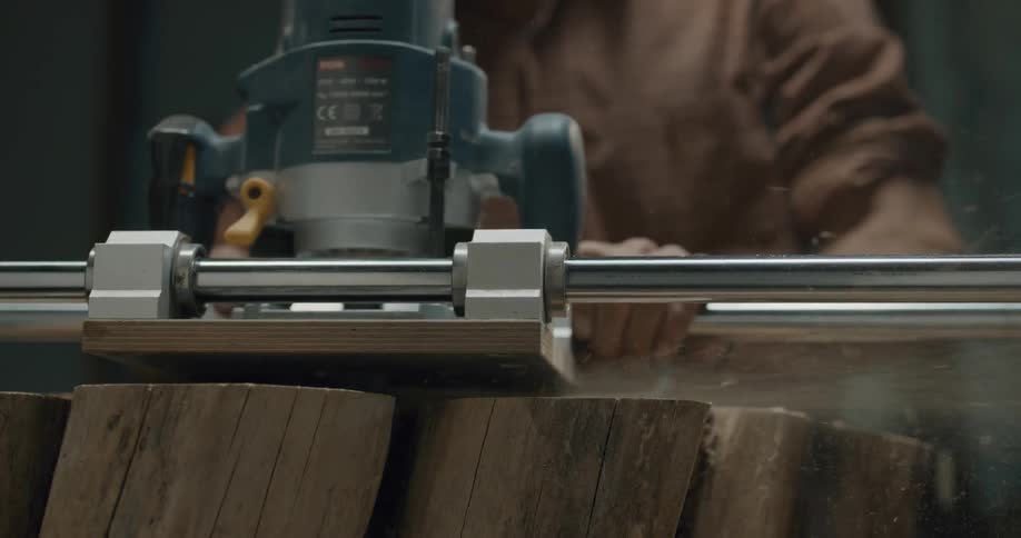 A carpenter cuts a piece of wood with a power saw