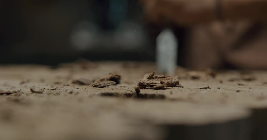 A person chiseling a piece of wood