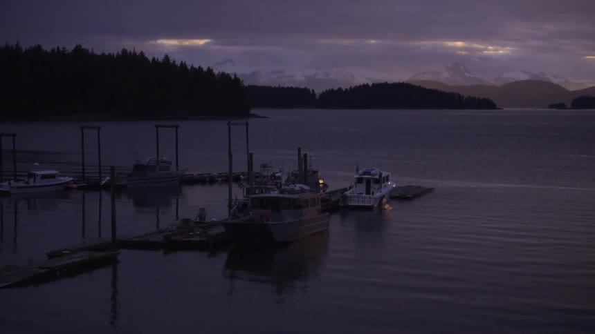 Boats float near docks on a mountain lake