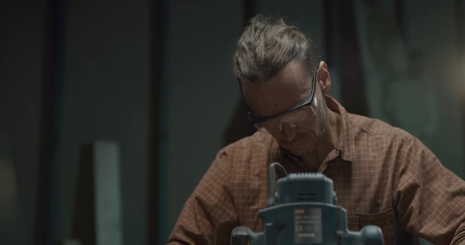 Man wearing safety glasses uses a sander