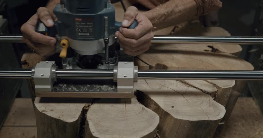 A person using a machine tool and their hands to sand a piece of wood