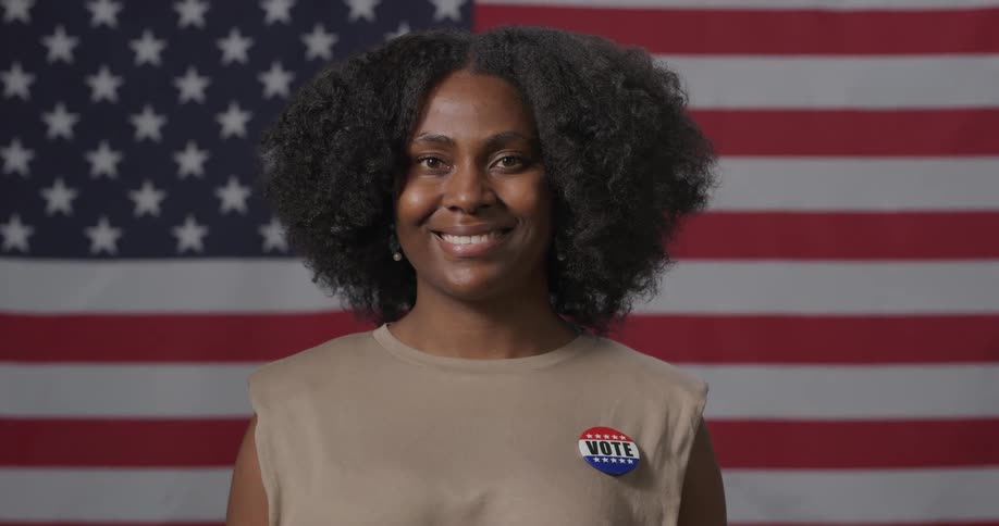 A young woman poses for a photo in front of the american flag
