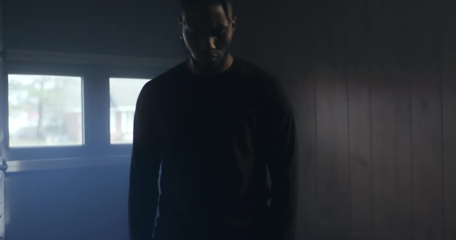 A man standing with his hands in a fist with a garage door behind him