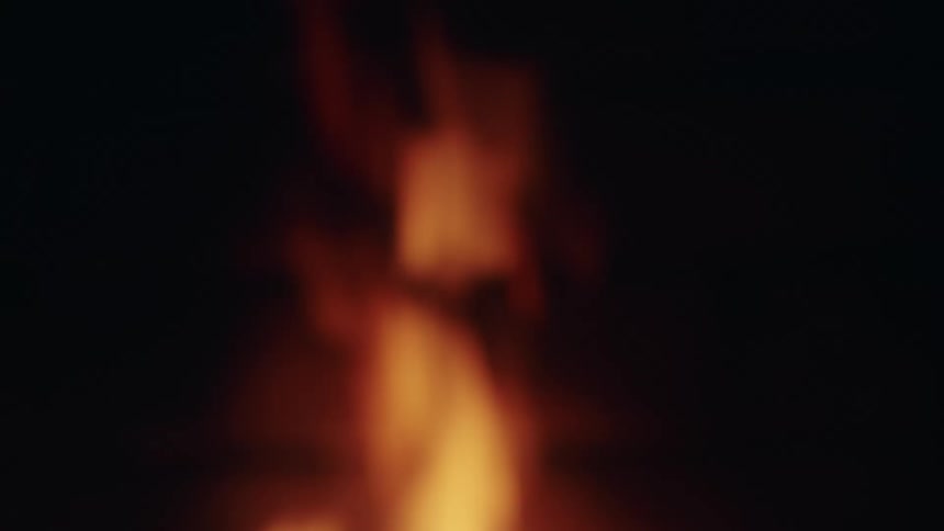 A fire is burning outdoors at night
