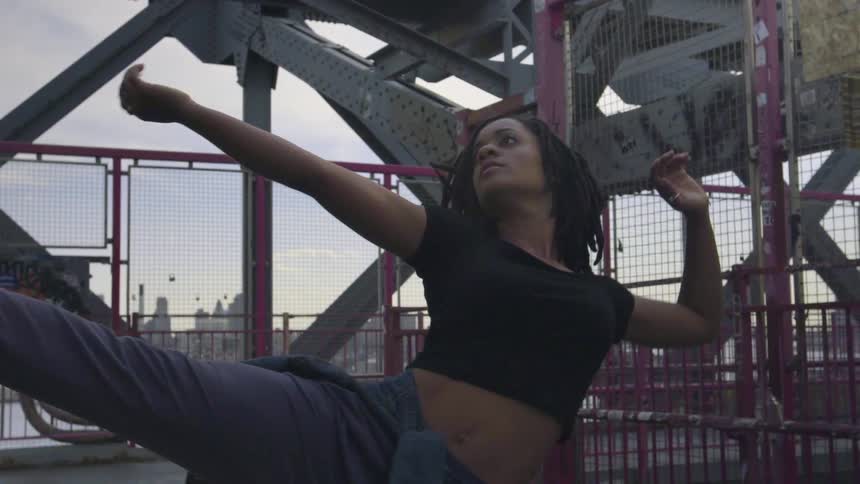 A woman is dancing outside on a cloudy day