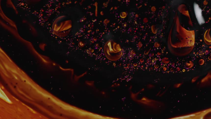 Movement of brown and yellow liquid and bubbles
