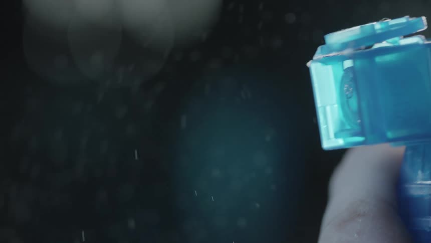 A person sprays a bottle and liquid mists out of it