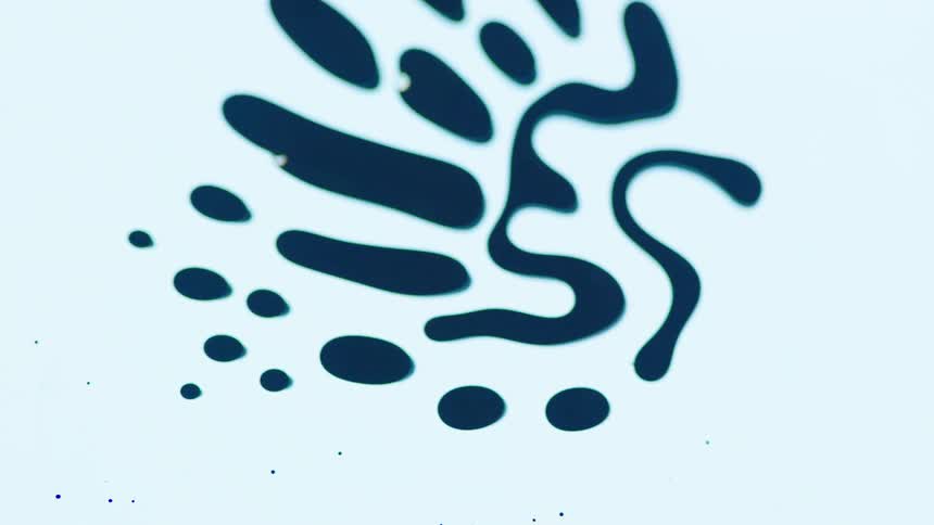 Dark droplets flowing in unison over a white surface