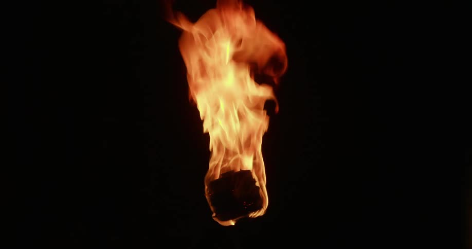 Orange flame of burning object contrasts with surrounded blackness