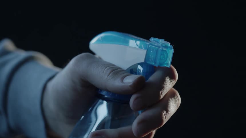A person is spraying a spray bottle