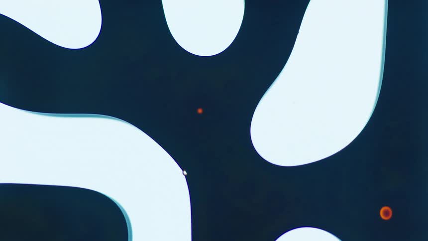 Small bits of orange liquid swirls with larger segments of black and white liquid