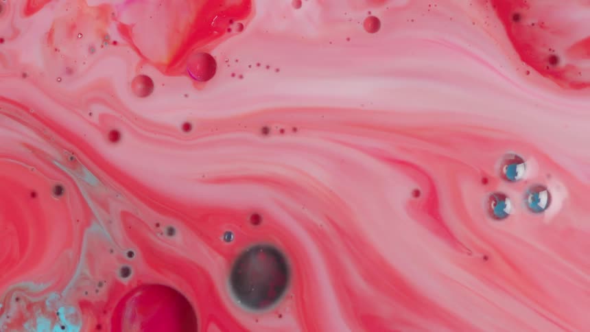 Pink and blue liquid and bubbles blend together