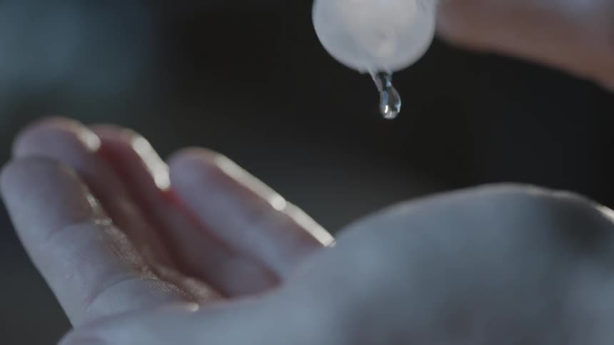 Pouring clear liquid from a bottle into your palm